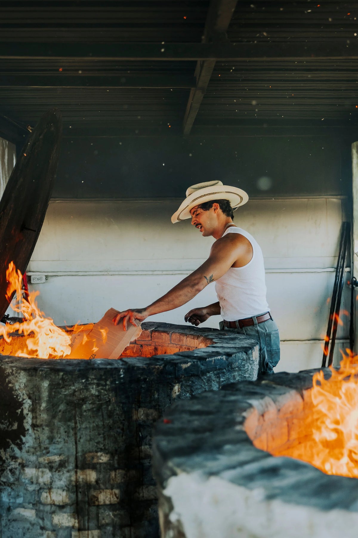 Adding wood to the El Grandpa barbacoa pit